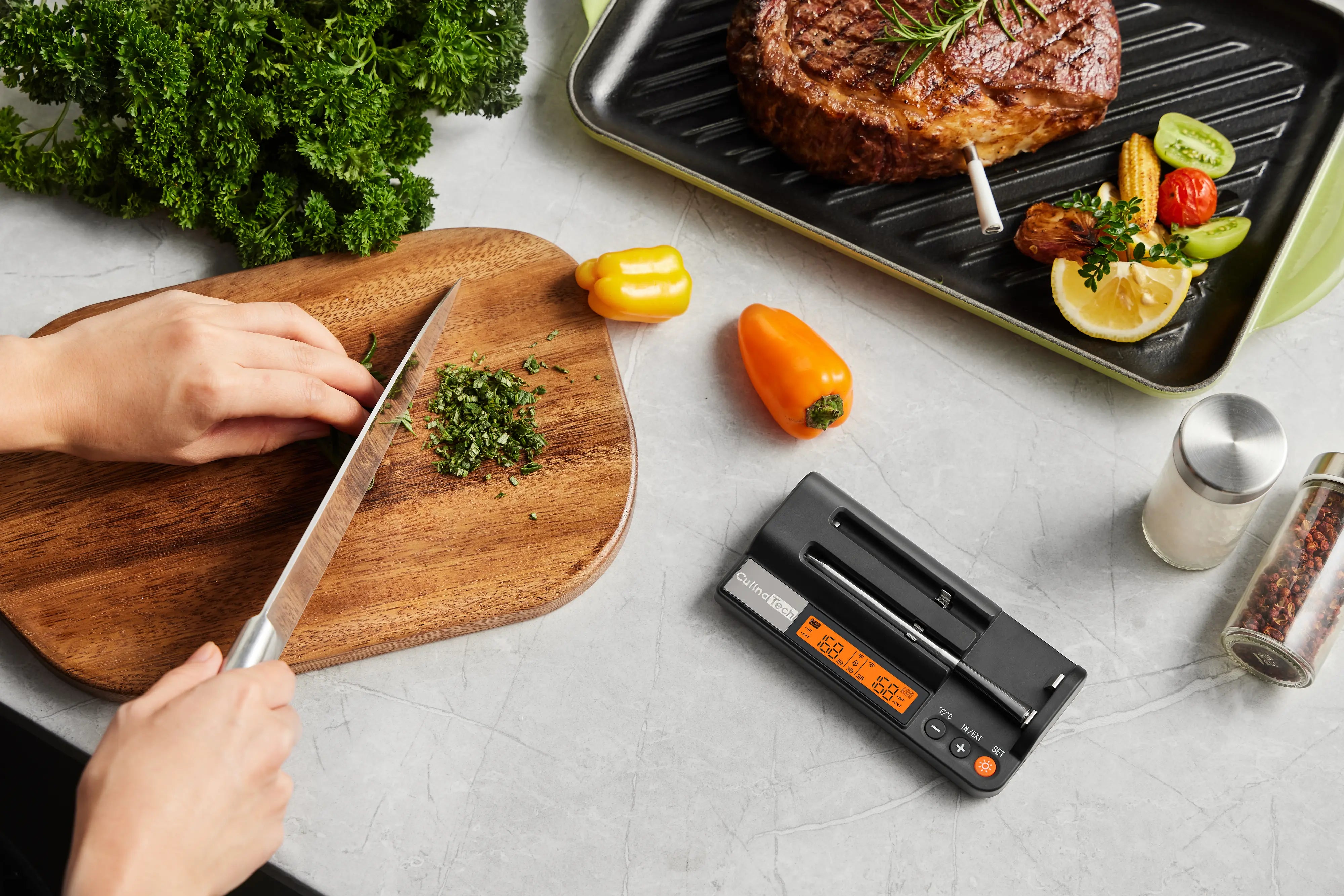 CulinaTech kitchen: herbs, peppers, grill pan with steak and thermometer, CulinaTech digital thermometer